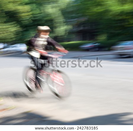Boy cyclist in traffic on the city roadway. Intentional motion blur