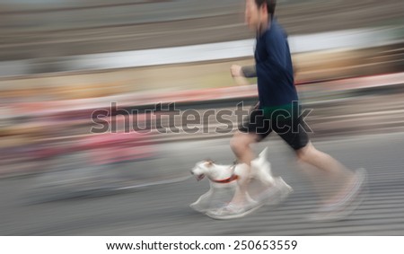 Man runs with his dog outside. Intentional motion blur