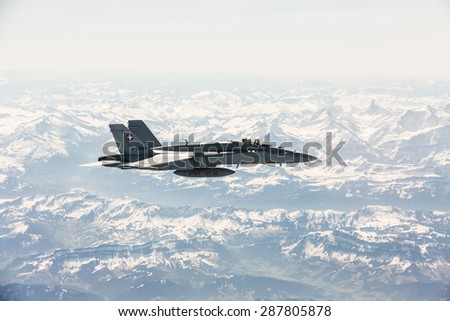 ALPS, SWITZERLAND - Apr 21, 2015: F-18 fighter jet of Swiss military air force on combat duty in the skies over Switzerland in the area of the Swiss Alps
