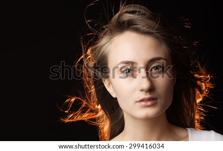 Portrait of a beautiful young woman on a dark background with copy-space
