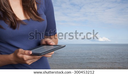 Young woman resting on the sea coast, and read e-books