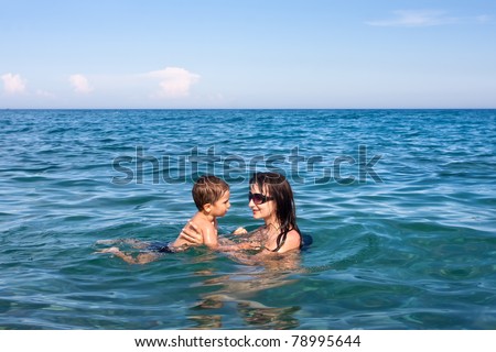 Mom teaches son to swim in the sea