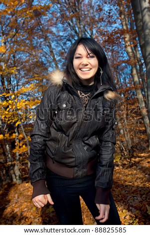 Smiling young woman in autumn forest