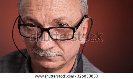 Close up portrait of an elderly man with glasses with copy-space