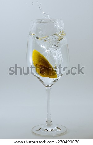 Lemon slice falling into Wineglass