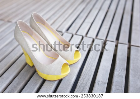 yellow ballet shoes and high heels open toe shoes on wood boards