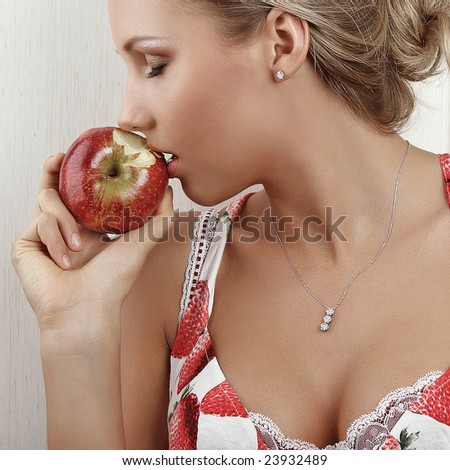 young attractive female holding and kissing an red apple