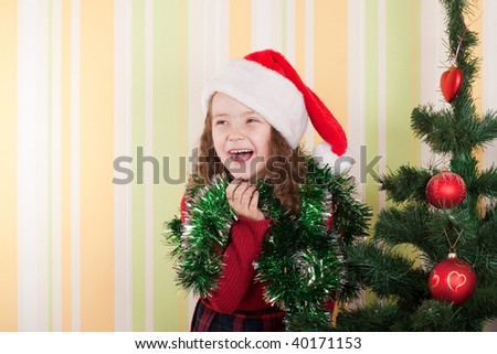 beautiful little girl standing near christmas tree