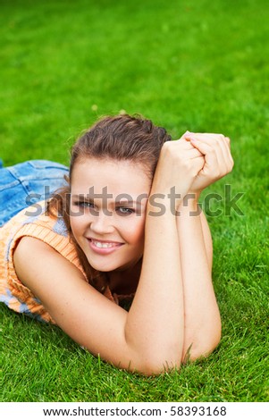 pretty young adult lying on lawn and laugh to the camera