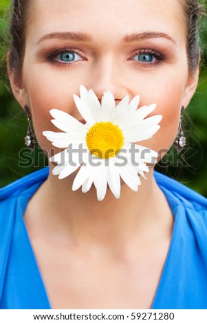 pretty young adult with mouth covered with camomile