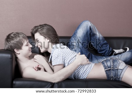 beautiful caucasian couple lying down on sofa