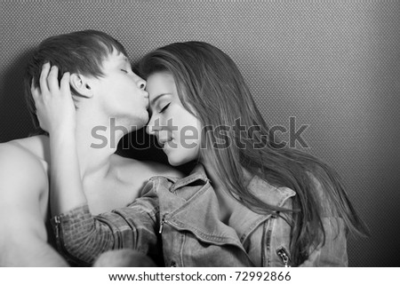 attractive caucasian couple hugs and kisses