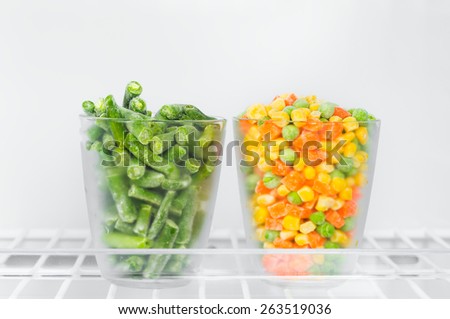 Frozen vegetables and legumes in the freezer, green beans, corn green peas and chopped carrots