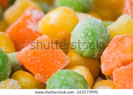 Frozen vegetables and legumes, corn, green peas, chopped carrots as food background, close up