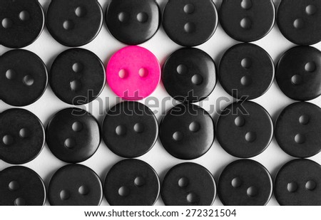 several rows of black buttons on a white background, among them the one bright pink, stands out concept, to be bright, life style