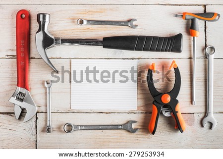 Greeting Card to Happy Father\'s Day, concept, set of different tools: a hammer, wrench, screwdriver, various spanners, clamp on a wooden background and tablet for an inscription, text, top view