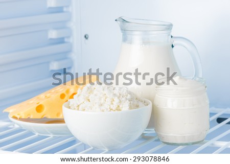 tasty healthy dairy products in the refrigerator: sour cream in the bank, cottage cheese in  bowl,  cheese  and milk in a jar