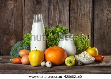 Set of different foods on the old wooden background, vegetables, fruit, eggs, dairy products, the concept of a balanced diet, vegetarian food