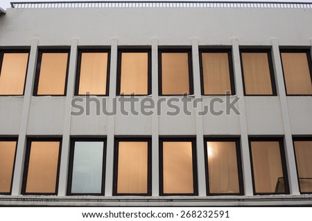 Windows background. Exterior building view in Reykjavik, Iceland with many orange windows and just one blue window.