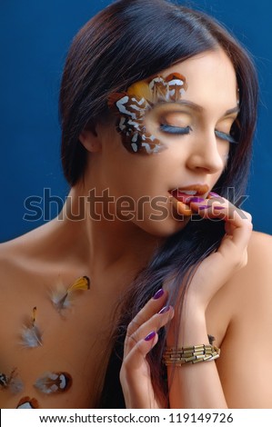 beautiful sexy woman topless with feathers isolated on blue