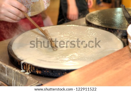 Woman baking delicious Russian pancakes popular for traditional Russian cuisine