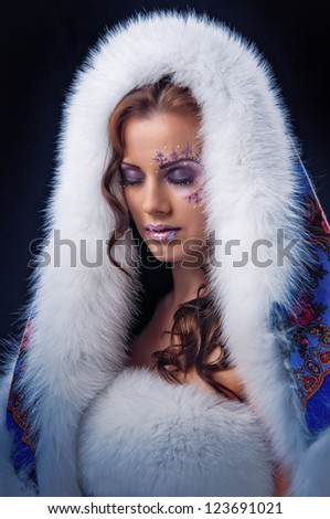 Winter girl with white fur hat wearing warm fur coat