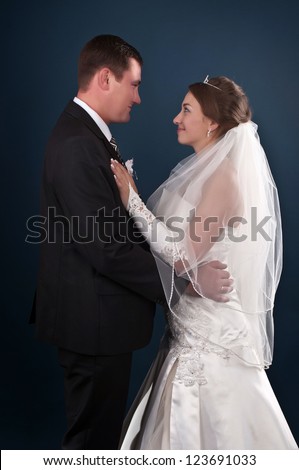Loving newlyweds standing on a blue background