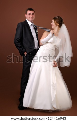 Loving newlyweds standing on a brown background