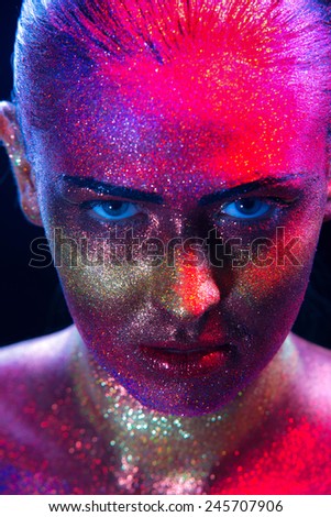 Glitter makeup on a beautiful woman face on a black background. Creative Contemporary Design
