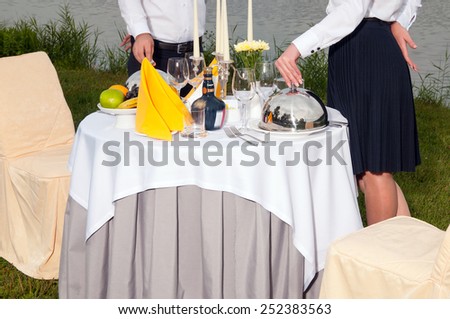 The fashionable holiday table outdoors on the banks of the river