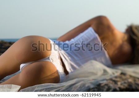 woman lying on a rock in a corset
