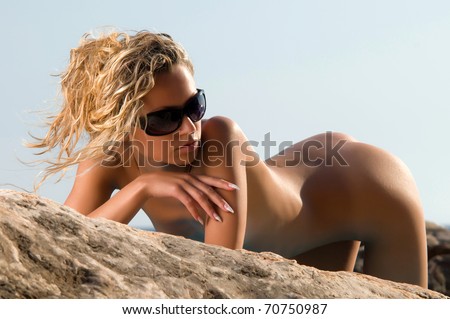 naked woman lying on a rock