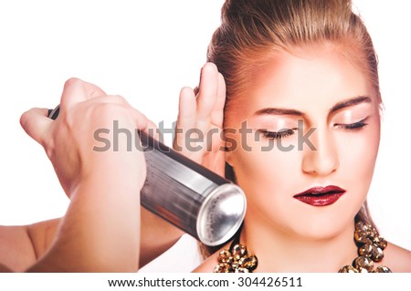 beauty, hairstyle and people concept - closeup of woman head and stylist hands with hair spray making hairdo at salon