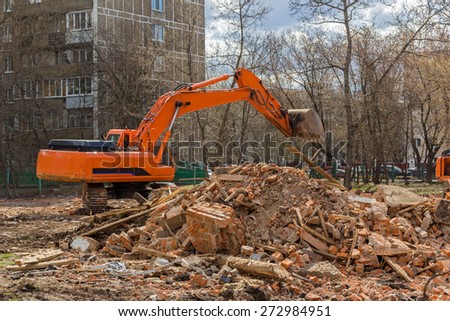 crawler excavator removes construction waste after building demolition