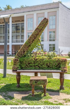 green topiary statue of a grand piano
