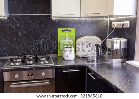 kitchen appliances on a black worktop with LED backlight