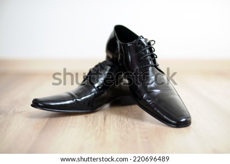 Shinny black mans shoes on the floor