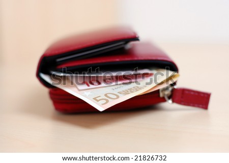 Open red leather wallet with euro banknotes