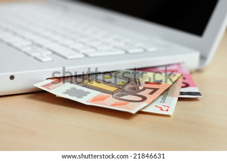 Euro banknotes and the computer (on-line shopping or on-line banking concept)