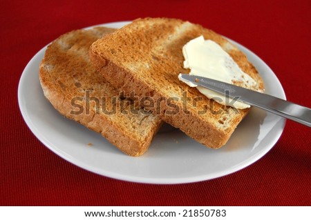 Spreading butter on hot French toast with a knife