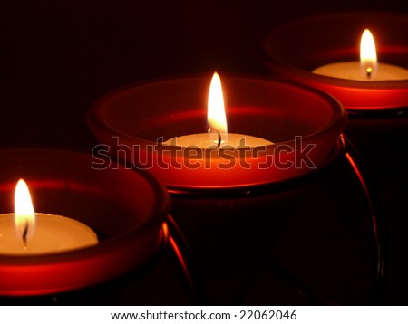 Three candles lit in the dark
