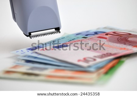 Euro banknotes and clipper (cutting costs concept)