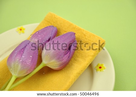 Wet purple tulips on a napkin and plate