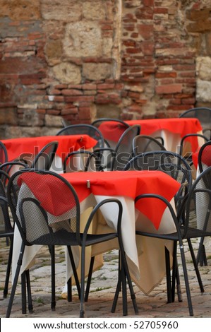 Empty restaurant chairs and tables in the old Italian street