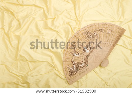 Asian fan with flying cranes on silk background.