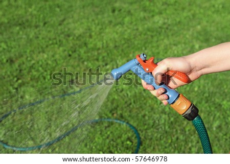 Garden hose in women\'s hand.