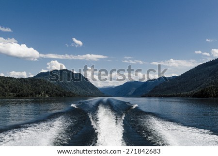Fishing speedy boat prop wash, white wake on the blue ocean sea