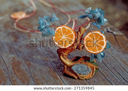 Earrings oranges from polymer clay and the tree handmade on the wooden background