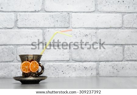 Earrings orange slices handmade from polymer clay on background of grey brick wall