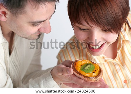 young man giving cake to his girlfriend